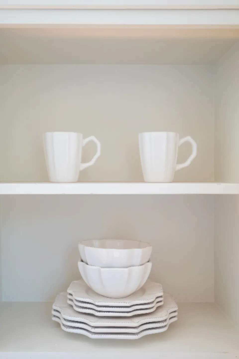 White open shelving holding mugs and stacked crockery