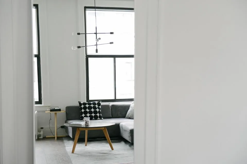 Bright living room with a grey sofa and a black-framed window