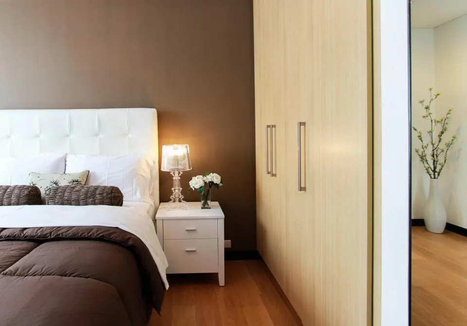 Bedroom with a run of pale fitted wardrobe doors beside the bed