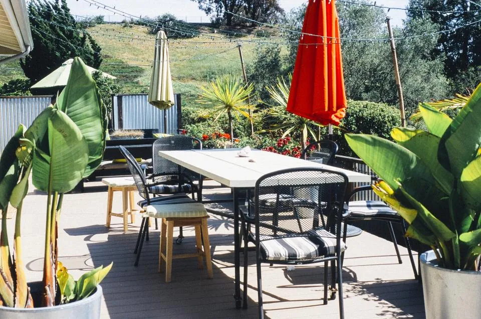 Roof terrace with a dining table, parasols and potted plants